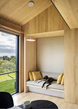 Schiller Projects designed and built many of the Chilmark House's freestanding furniture pieces. In the living area, the family dog reclines on an upholstered bench.