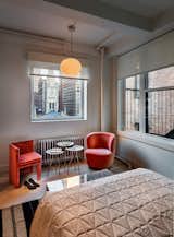 Bedroom, Bed, Chair, Rug Floor, Ceiling Lighting, and Medium Hardwood Floor  Photo 7 of 8 in Empire State Apartment by Schiller Projects