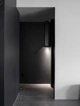 A hall light detail that discretely illuminates the floor of the black hallway.