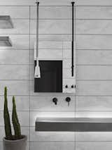 The floating drain-less custom sink with led backlighting with matching corner shelves by Compound Concrete. Paired with hanging mirror and pendant outlet.