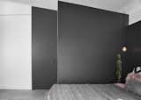 The custom sliding bathroom door by Dotzler Design was made to disappear into the black wrap-around headboard of the bed.