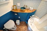 The bathroom, which features a penny-tile floor, is relatively large—and even holds a soaking tub.