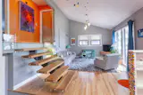 The existing stairs and railing were replaced with a floating staircase and glass panels, creating a more modern feel to this 1958 home. Vintage furniture collected at resale and antique shops.