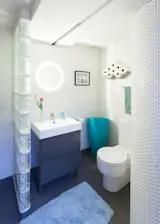 This curved shower wall adds a sculptural element to this geometric inspired bathroom.
