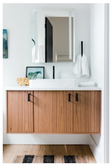 The bathrooms have been kept simple, with white walls and wood cabinetry keeping the area light, bright, and airy.