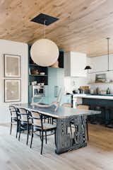 In the kitchen, statement lighting by Nuevo Living, blue-green cabinets, and an intricately carved wooden table juxtaposes modern living with rustic touches. The Deco ceiling accent cover plate is by Gault Designs&nbsp;