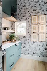 Swallow-printed wallpaper adds depth and pattern to the subdued kitchen color palette.&nbsp;
