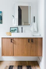 The bathrooms’ white walls and wood cabinetry keep the areas light, bright, and airy.