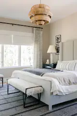 The master bedroom assumes a "layered, masculine vibe" that plays off the sweeping tree views outside. A wood-inspired light further plays off the views.