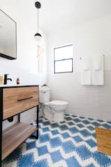A combination of crisp white walls and funky floor tile lends big personality to this bathroom.