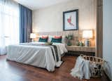 Bedroom, Night Stands, Bed, Medium Hardwood Floor, and Table Lighting  Photo 10 of 10 in The Rain-forest Explorer Home by SQR Architecture + Interior Design