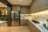 Kitchen, Ceiling Lighting, Wood Cabinet, Vinyl Floor, Refrigerator, Marble Backsplashe, Engineered Quartz Counter, Drop In Sink, Recessed Lighting, and Microwave Pleasant kitchen space for homecooks.  Photo 7 of 17 in Posh & Polished : State-Of-The-Art Residence by SQR Architecture + Interior Design