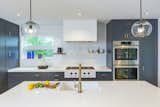 Kitchen, Ceiling Lighting, Colorful Cabinet, Microwave, Subway Tile Backsplashe, Range, Range Hood, Wall Oven, Undermount Sink, and Pendant Lighting  Photo 4 of 27 in Lookout House by Robert Hintz