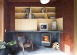 Openings in the library’s Redwood burl lining reveal a ‘core’ of American Ash millwork. Soapstone provides a mantel and backing for the wood-burning fireplace