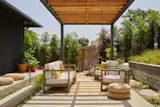 The outdoor pergola reflects the color of the home and adds warmth by using the natural color of the wood used for the horizontal elements, repeated vertically in the fence. 
