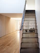 The sleeping loft stair is both foreground and background, heavy and light. The white guardrail is a single 3/8” thick painted steel plate. The treads and risers are folded perforated steel, acting as a single monolithic structure.