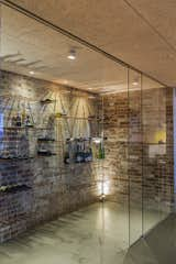 Dining Room, Concrete Floor, Lamps, Ceiling Lighting, Shelves, and Wall Lighting Rough, original brickwork and glass – and a collection of fine wines. Jesper designed the storage solution in the wine cellar, which can now be purchased from Erbs Design. As in the other rooms of the house, there was a clear strategy for lighting.  Photo 11 of 15 in The Architect's backyard home by Anita Barner Ibsen