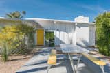 Krisel's own firm designed nearly 40,000 homes around Southern California, incorporating many of his signature features, such a low-slung roof. Today, a golden yellow front door offers a cheerful welcome against the white facade.