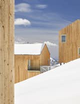 Some cabins follow the mountain's contours while a cross-grain version juts out over the blanket of snow.