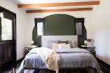 Rustic wood beams and a painted green arch create a soothing background for the master bedroom. Here, like the guest room, the bed is from Inmod.