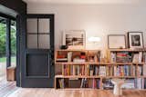 Shelves, filled with books and objects, are a focal point of the living room.