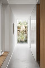 Punctuating a hallway with light was among the clients' few requests for the house. EFFEKT achieved it through a panel of glass that highlights a swath of greenery.