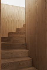 The sculptural oak staircase reinforces the villa's predilection for simplicity and natural materials.