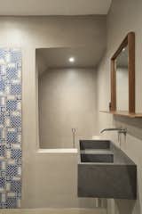 The interplay of old and new also stars in another bathroom, where ceramic tiles recovered on site complement a custom lava stone sink.