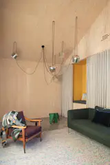 Suspended aluminum AIM pendants from FLOS hang in the media/playroom, which includes an Eames Elephant and a clever pocket wall nook for reading and screen time.

