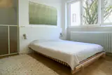 The cramped former kitchen has given way to the breezy primary bedroom, accented with an Abra rug and a duo of Normann Copenhagen Klip wall lamps. Above the Cubile bed from Collaboratorio, topped with a Matri Aava bedspread, hangs a tapestry made by a friend that brings to life a photograph Sarolta took during her time in Burundi.