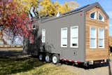 The back of the tiny home carries a sleek design with steel grey cladding while the cedar is integrated with a modern and bold fascia line. 