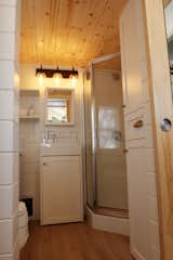 The bathroom also houses a 36"x36" neoangle shower and a large storage cabinet that houses the electric hot water tank and clothing.