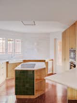 Kitchen, Microwave, Wood Cabinet, Cooktops, Marble Counter, Refrigerator, Dishwasher, Ceramic Tile Backsplashe, Wall Lighting, Terrazzo Floor, and Wall Oven the island of the kitchen plays with ceramic   Photo 20 of 27 in Tangram house by twobo arquitectura
