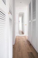 An all-white walk-in closet design creates a brighter and more expansive perception of the space