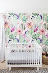 Whimsical wallpaper provides the perfect backdrop for this baby's bed. 