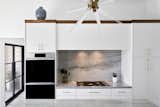 Modern clean design perfect for the active chef, lots of light and cabinet space.  Decor  Heritage model double oven and  Decor gas stove  with gold trim gives it warmth and elegance. The walnut accent adds a nice contrast to the all white cabinets and high ceilings. 