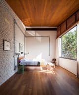 Bedroom, Bed, Medium Hardwood Floor, Wall Lighting, and Chair  Photo 19 of 22 in Conde D'eu House by Estúdio Penha