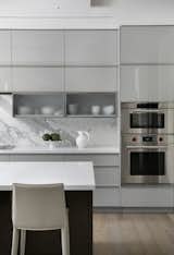 Kitchen with laminate custom cabinetry and Calacata marble backsplash with quartz counters