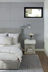Master Bedroom with upholstered wall,  motorized shade, and custom nightstand with docking drawer outlet