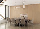 Dining Room with wood paneled wall and concealed cabinets.  Wood paneled wine and drink fridge, marble niche