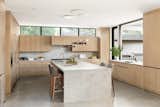 Kitchen with wood paneled appliances porcelain counters and pass through window to outdoor counter seating