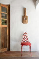 One of the rare points of color in this project is the Cobra Coral chair, created by Sergio Matos. Resting on it, a decorative piece of wood from Divino’s Trancoso. Observe also the subtle wavy walls - effect of the santa-fe plaster, common both in mexican houses and in spanish and mediterranean dwellings