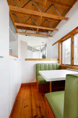 A built-in breakfast nook in the kitchen sits near a wall of open and concealed storage.