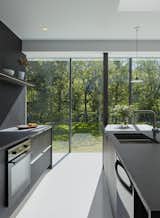 The kitchen in 1220 E. 12th Street House features floor-to-ceiling windows that look out on a serene grove of oak trees. The project was designed by Studio 804, a graduate student architecture and design program led by Dan Rockhill at the University of Kansas.