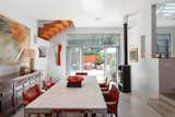 Expansive dining room with 12' ceilings and RAIS Scandinavian wood burning stove. Light enters and reflects in the space through the wall of glass, sliders and openings in the staircase above.