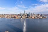 Floor-to-ceiling windows frame dramatic vistas of the Manhattan skyline, World Trade Center, New York Harbor and Statue of Liberty.  