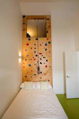 Peaked ceilings can be used to create clever spaces, like this storage loft. And what better way to access it than a climbing wall!