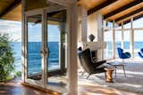 Living Room, Rug Floor, Ottomans, Chair, Light Hardwood Floor, End Tables, Standard Layout Fireplace, Travertine Floor, and Floor Lighting Living Room with Panoramic Ocean View  Photo 5 of 22 in Sea Spray La Jolla by Drew & Tim Nelson