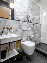 The black-and-white bathroom has gold fixture accents.