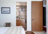 The bedroom and adjacent bathroom have coastal modern vibes.